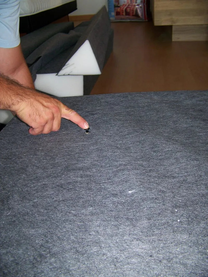 Détail d'une fixation du revêtement sur la mousse