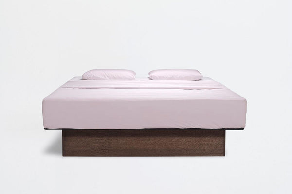 Lit à eau Akva Soft vu de face : matelas habillé de blanc sur un socle en bois foncé, sans tête de lit