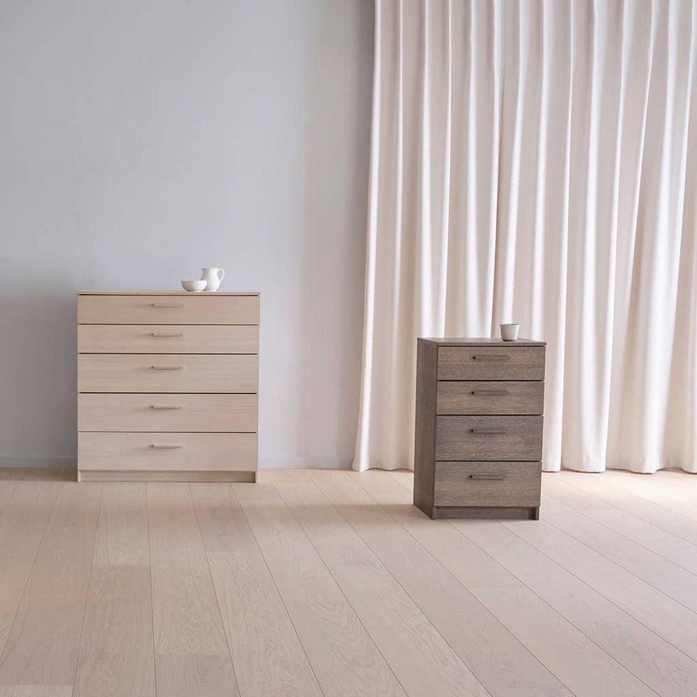 Deux commodes Akva en scène : 100 cm à cinq tiroirs en placage clair et 50 cm à quatre tiroirs
