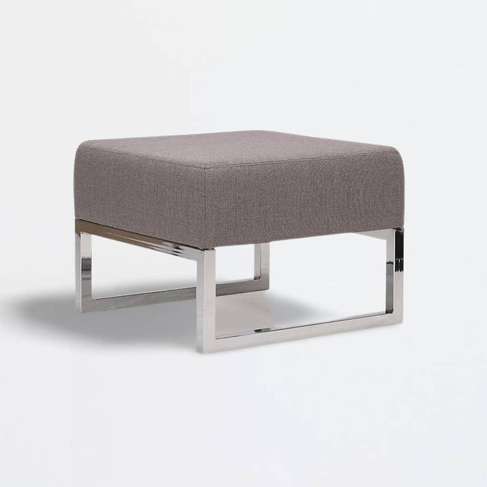 Pouf Akva Vega vu de trois quarts : assise tapissée grise et piètement chromé