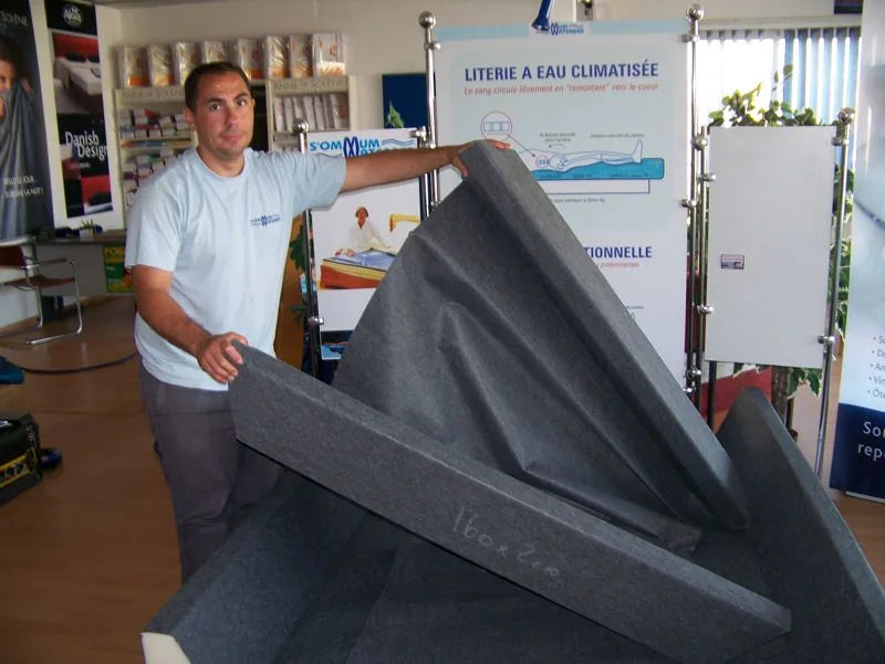 Un conseiller présente un panneau de mousse du cadre softside, en showroom.